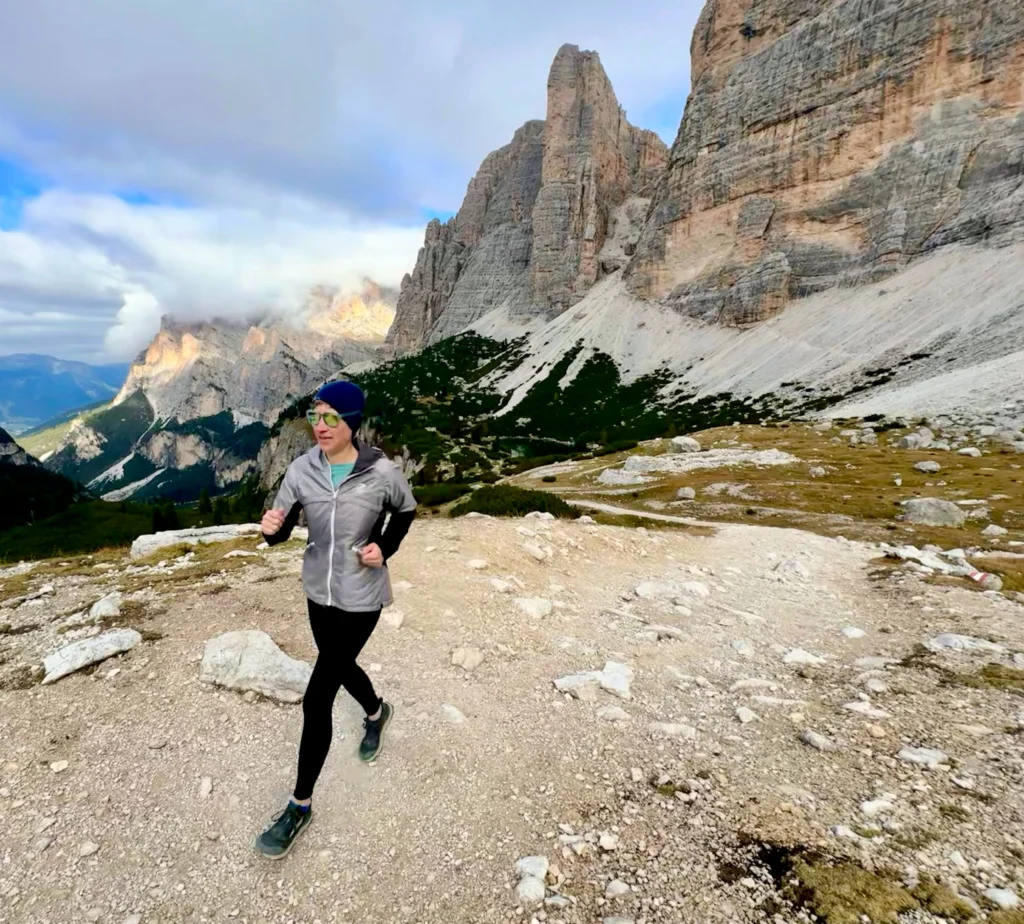 Running up a rocky path among the clouds and surrounded by rocky cliffs.