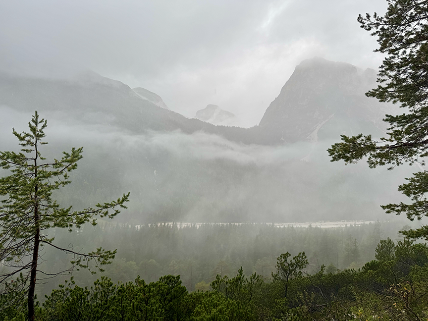 A view of mountains just becoming visible as fog and clouds lift.