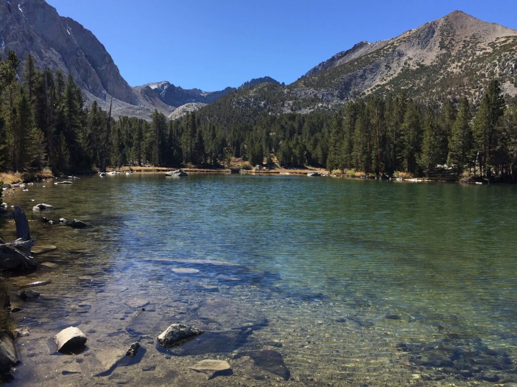 Mountains towering over a clear blue-green lake.